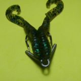 A green bug with two metal legs on top of it.