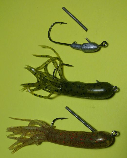 Three different types of fishing hooks on a green surface.