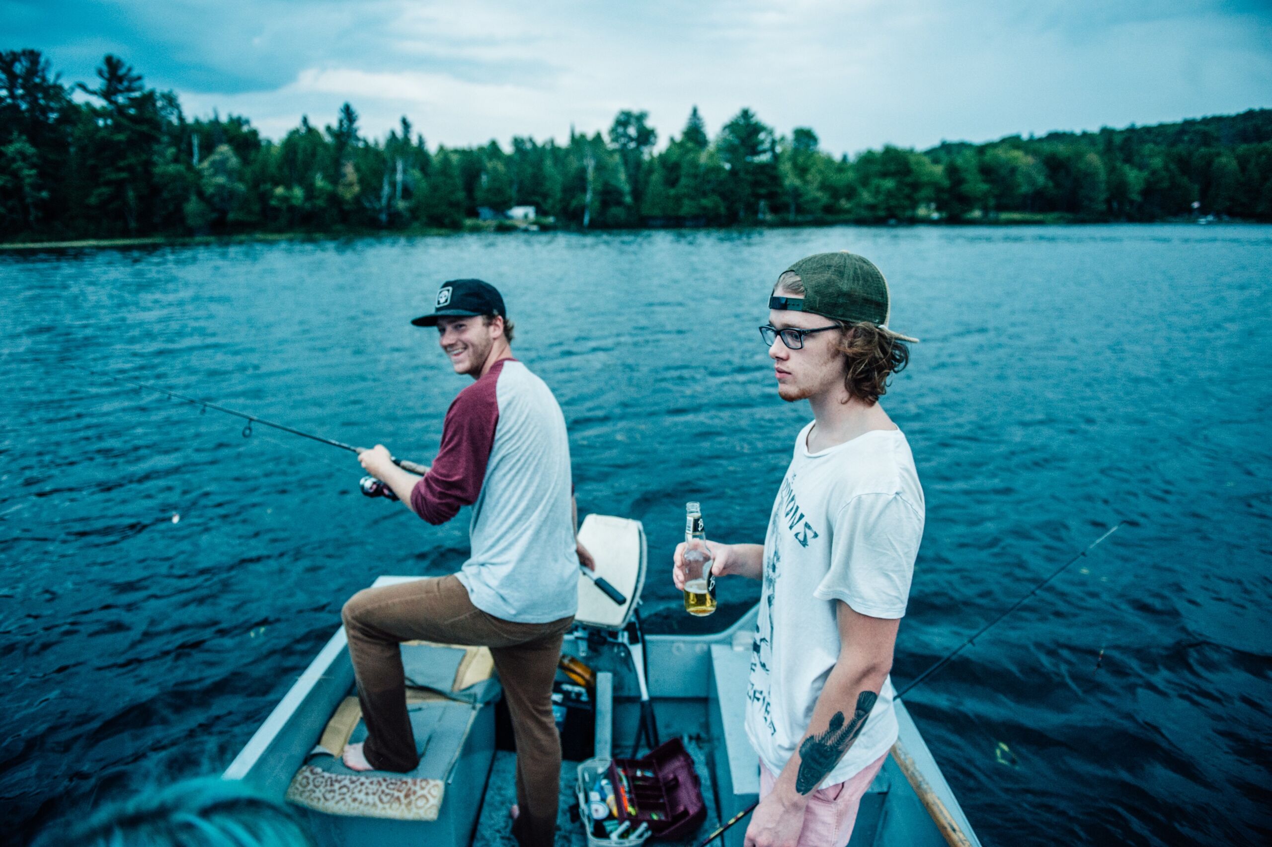 Two men are fishing on a boat in the water.
