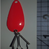 A red key chain hanging on the wall.