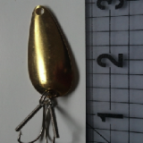 A gold spoon with four hooks attached to it.