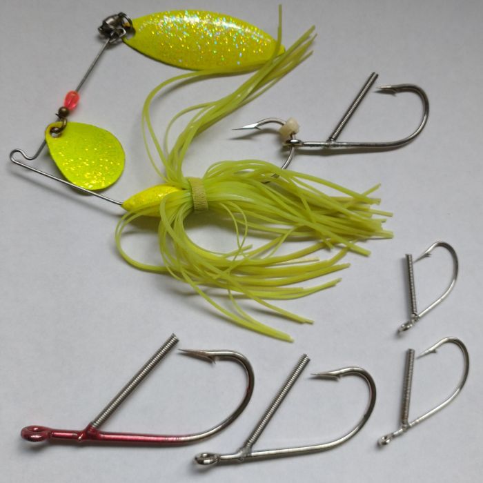 A group of fishing hooks and a yellow lure.